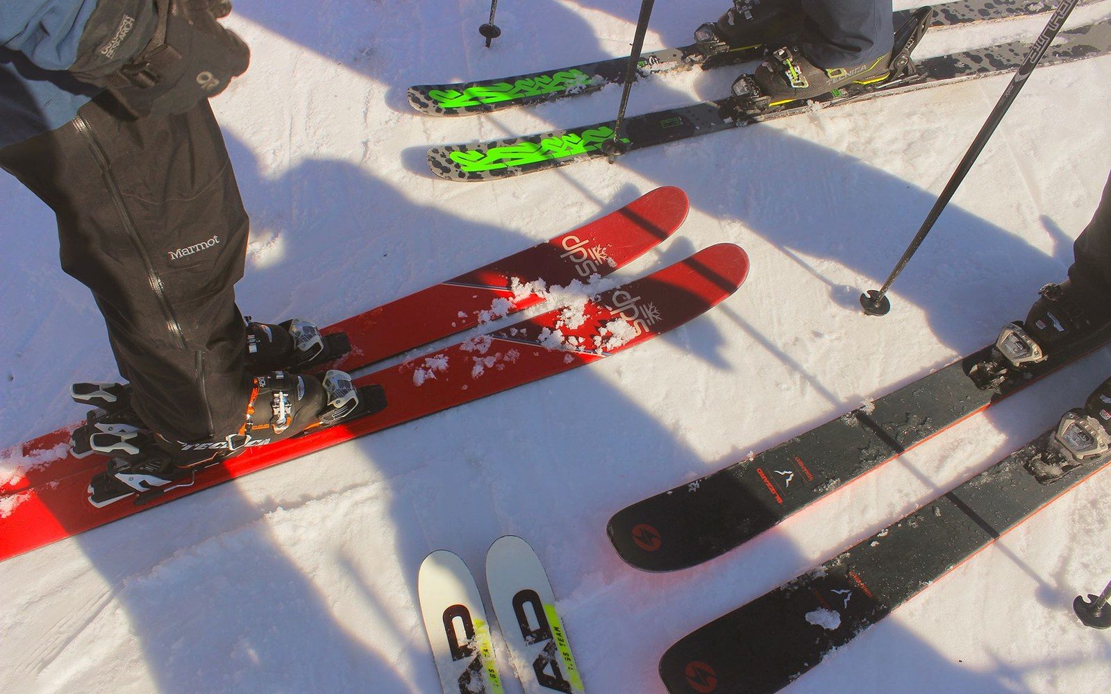 NTN binding mounted on a ski, shot from directly above, the toe plate and pivot mechanism visible against the ski's topsheet