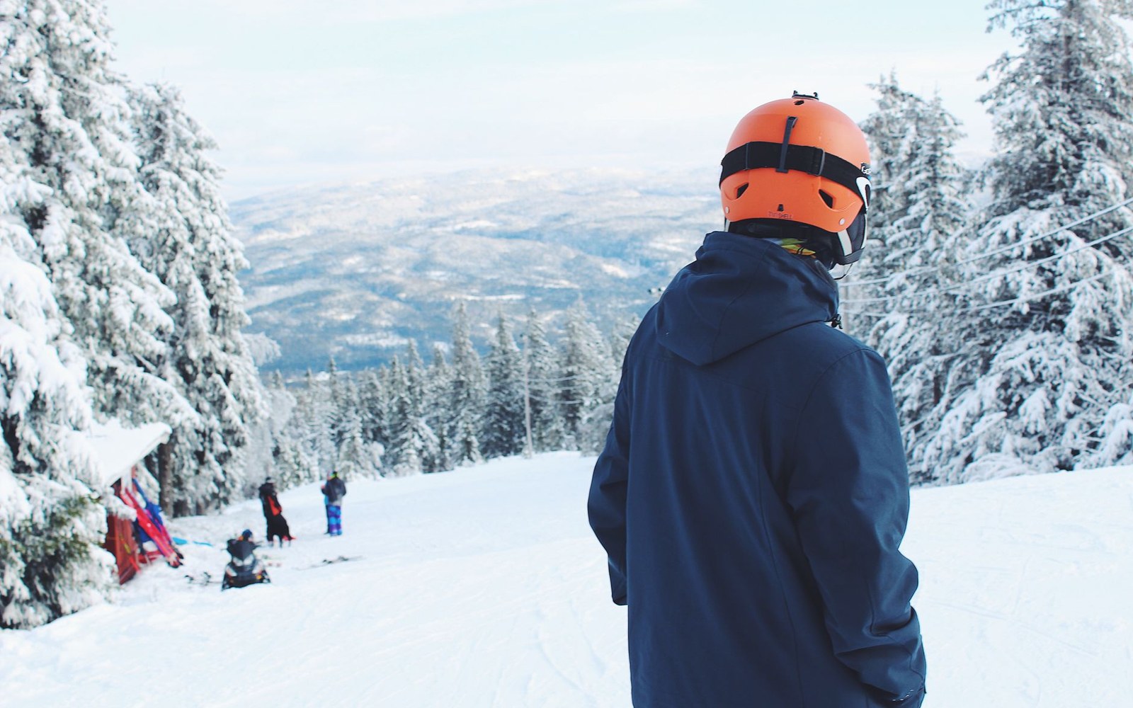 Skier mid-lead-change on open terrain under flat winter overcast light
